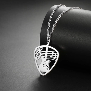 Macro shot of silver guitar pick necklace pendant featuring intricate musical notes