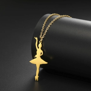 Close-up of golden ballerina pendant necklace hanging on a matte black display stand