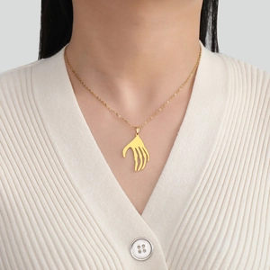 Collier avec pendentif main de squelette doré style punk sur tricot minimaliste