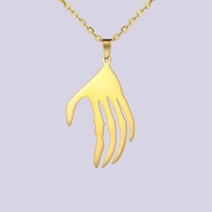 Vue détaillée du pendentif main de squelette dorée punk et de sa fine chaîne en métal