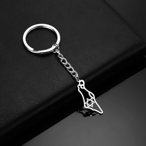 Detailed macro of stainless steel mountain map keychain with hexagram star on black leather