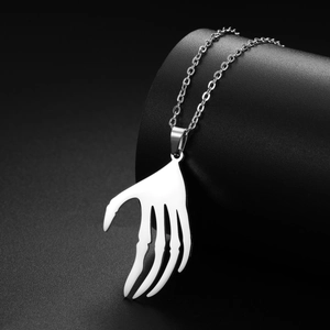 Détail d'un pendentif main de squelette en acier punk sur un support noir élégant