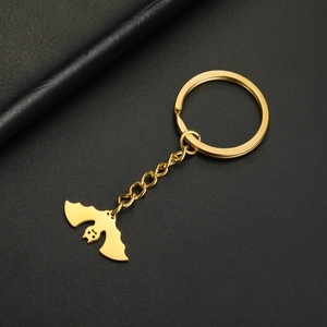 Detail view of the polished golden bat pendant on a stainless steel keychain link