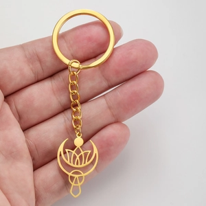 Porte-clés doré en acier inoxydable avec croissant de lune et lotus tenu en main