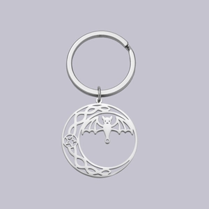 Detailed view of silver stainless steel crescent moon keychain with bat and pentagram detail