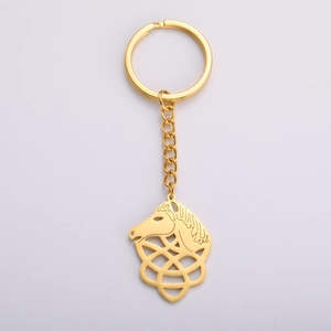 Detail of a polished gold horse head pendant with intricate Celtic knot patterns