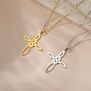 Gros plan de pendentifs croix nœud celtique en or et argent sur fond de pierre