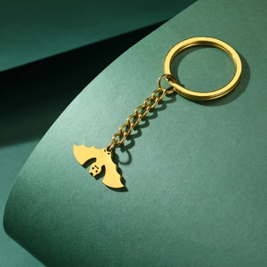 Close-up of golden stainless steel bat pendant on keychain with smooth metallic finish