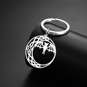 Detailed macro shot of a gothic bat and crescent moon pendant on a silver keychain