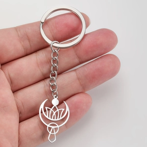 Porte-clés minimaliste lotus et croissant de lune en acier inoxydable tenu à la main