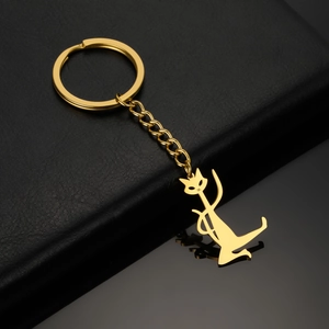 Detailed view of a golden hollow cat keychain on a premium black leather and mirror surface