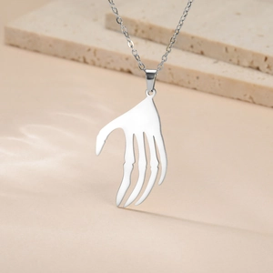 Détail d'un pendentif main de squelette argenté sur une chaîne en acier de style punk