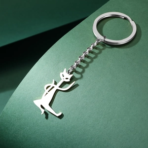 Polished silver stainless steel kung fu cat pendant keychain on dark green background