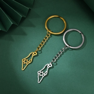 Close-up of gold and silver Israel map keychains with Star of David over dark green background