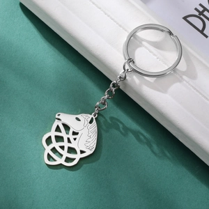 Detail of silver stainless steel horse head keychain with Celtic knot on dark green background
