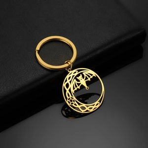 Detailed close-up of golden stainless steel keychain with bat and pentagram cutout design