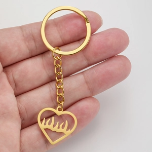 Porte-clés punk en acier inoxydable doré avec pendentif cœur ajouré motif flamme en main
