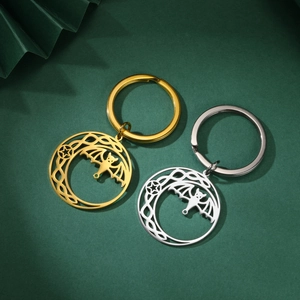 Detailed close-up of gold and silver gothic crescent moon and bat keychain in celtic style