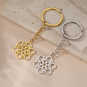 Porte-clés géométriques hexagonaux polis en or et argent sur fond de pierre