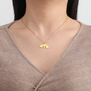 Collana con ciondolo a pipistrello dorato su modella con catena in acciaio inossidabile lucido