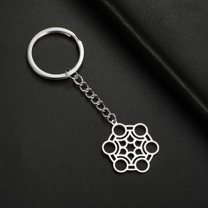 Gros plan d'un pendentif hexagonal argenté sur un porte-clés en acier inoxydable poli