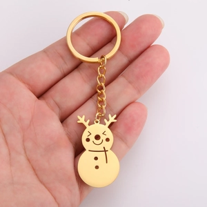 Detail of hand-held gold snowman keychain featuring reindeer antlers and polished finish