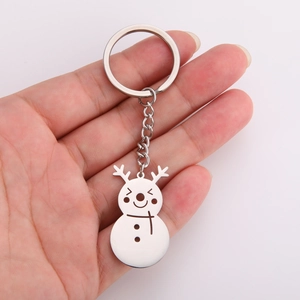 Close-up of golden snowman keychain with reindeer horns and festive scarf detail