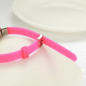Detailed macro view of adjustable pink silicone strap with silver buckle and adjustment holes