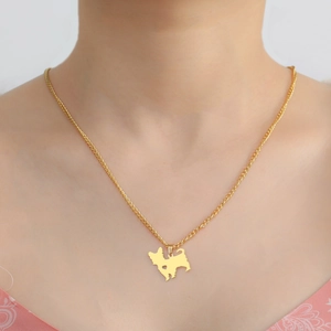 Close-up of a gold stainless steel necklace with a cute dog silhouette and heart cutout