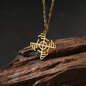 Detailed close-up of golden windmill geometric pendant necklace on rustic wooden stand
