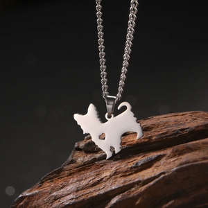 Macro shot of silver stainless steel dog pendant with heart cutout on wood