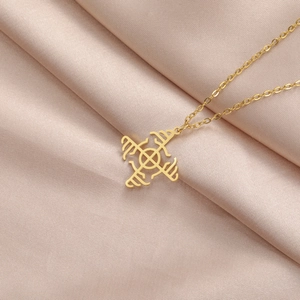 Macro shot of gold stainless steel geometric pendant on champagne satin fabric