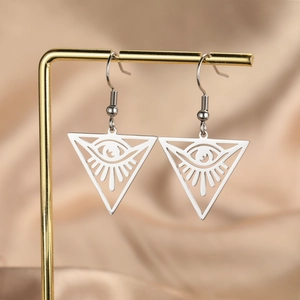 Silver triangle evil eye drop earrings in stainless steel on a luxury silk display