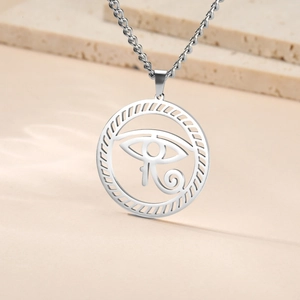 Detailed macro shot of vintage silver Eye of Horus pendant on O-chain with stone background