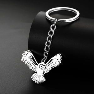 Vue détaillée du porte-clés hibou en métal avec ailes ajourées sur support noir