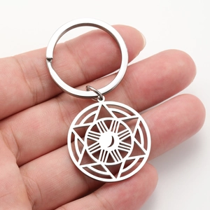 Stainless steel keychain with celestial moon and star pendant held in hand