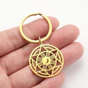 Detail of a golden stainless steel keychain with sun moon and star pendant charms