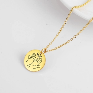Goldene Edelstahlkette mit rundem Anhänger und einer Gravur von klatschenden Händen