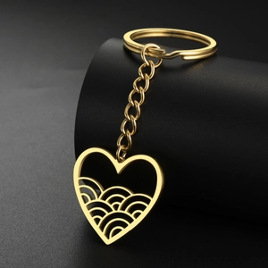 Close-up of golden stainless steel hollow heart keychain with elegant wave pattern