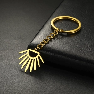 Macro view of gold stainless steel sunburst keychain with hollow fan-shaped pendant