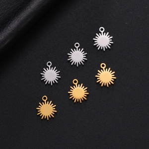 Close-up of gold and silver sunburst charms for DIY jewelry on black background