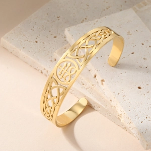 Detailed close-up of a gold 18K stainless steel cuff bangle with Celtic knot engraving