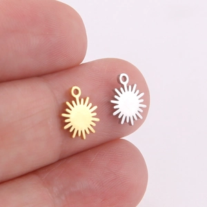 Macro shot of small sun-shaped jewelry charms in gold and silver finish for DIY