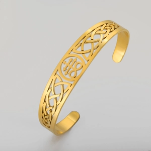 Detailed macro view of gold hollow-out engraved cuff bracelet with Celtic knot patterns