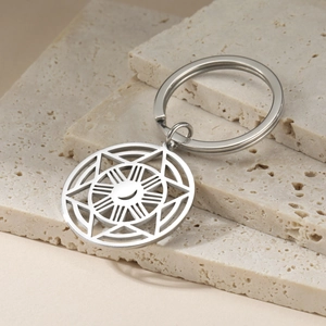 Macro detail of stainless steel keychain featuring celestial sun and moon cutout charms
