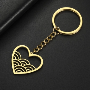 Detailed view of gold heart-shaped keychain with intricate hollow wave pattern engraving