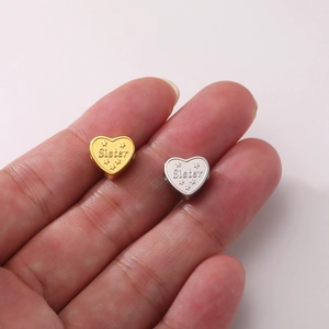 Detailed close-up of heart-shaped Sister charms in silver and gold for DIY jewelry