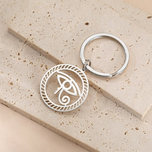 Detail of Eye of Horus stainless steel keychain on a textured stone display