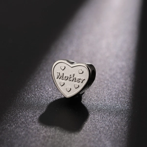 Detailed view of silver heart charm with Mother engraving and small heart details