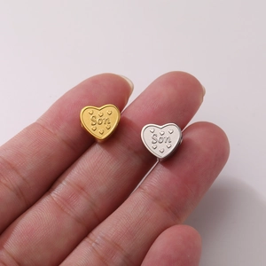 Macro detail of heart-shaped stainless steel charm with engraved Son text for DIY jewelry